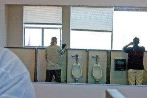 Two men stand in the men's toilet