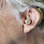 The side of a deaf person's head, showing an ear with a hearing aid