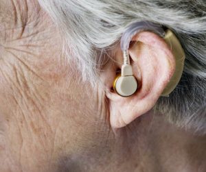 The side of a deaf person's head, showing an ear with a hearing aid
